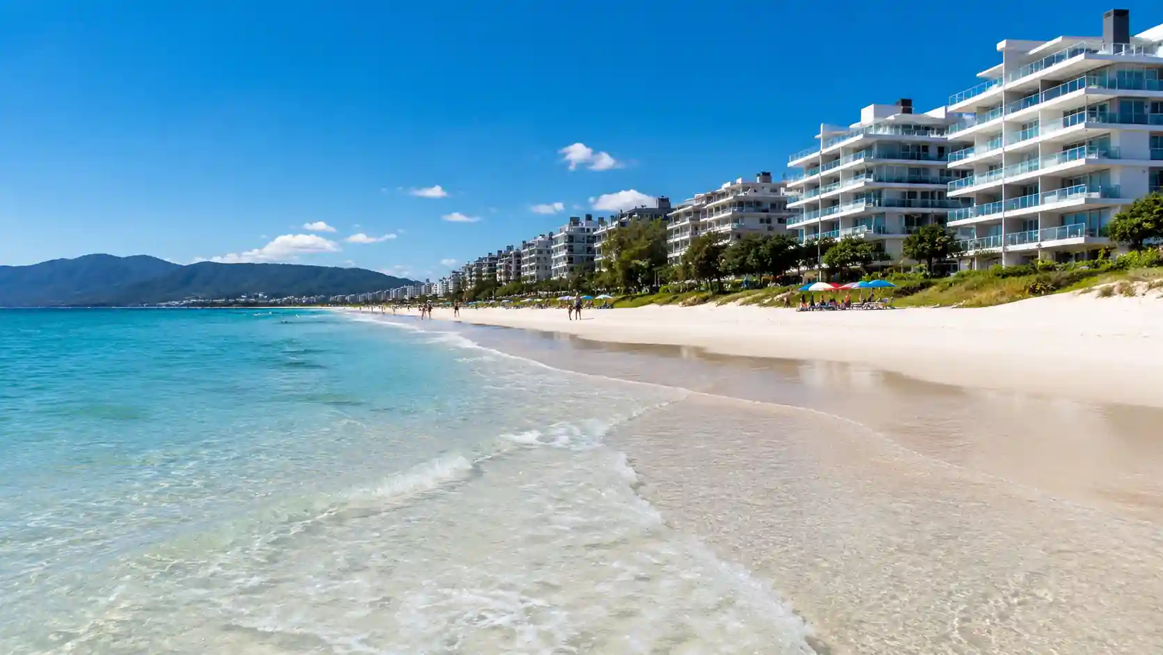 Praia de Campeche Florianópolis com areia branca e condomínios ao fundo