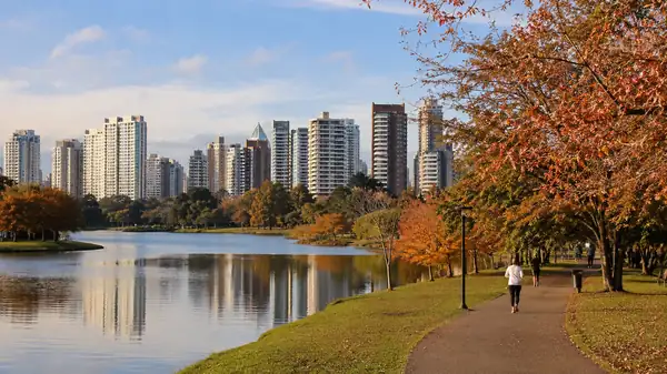 Parque Barigui Curitiba com prédios residenciais ao fundo em dia de outono